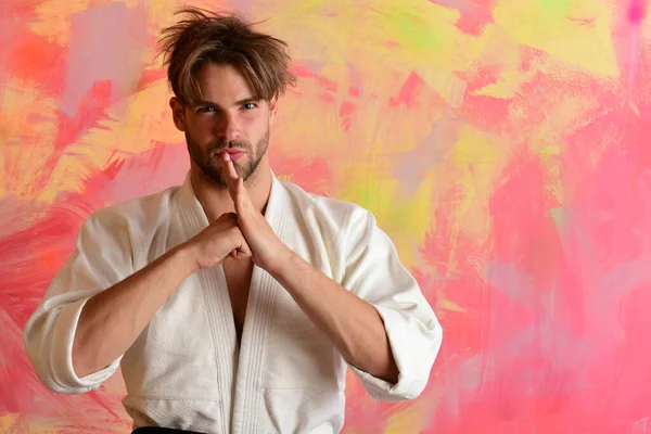 Japanese karate concept. Guy poses in white kimono.