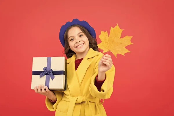 Venta estacional. Oferta de otoño. Niña y caja de regalo. Muchacho lindo cara mantenga hoja de arce. Niño con hoja de otoño recibido presente. Compras de otoño. Viernes Negro. Pequeña niña caída traje rojo fondo —  Fotos de Stock