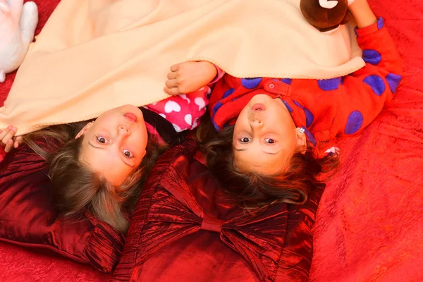 Pijamalı çocuklar kırmızı arka planda surat yapar.. — Stok fotoğraf