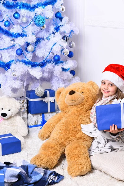 Weihnachtszeit. Liebenswertes Kind hält großen Bären — Stockfoto