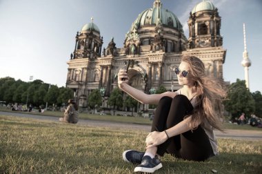 Berlin Katedrali 'nin önünde oturmuş selfie çekiyordu.