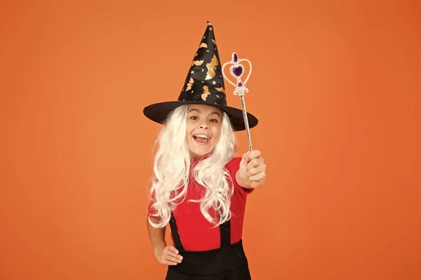 Enjoying carefree time. believe in magic. smiling small girl halloween party. mystery witch do magic. small child witch hat. trick or treat. kid enchantress wave magic wand. happy halloween — Stock Photo, Image