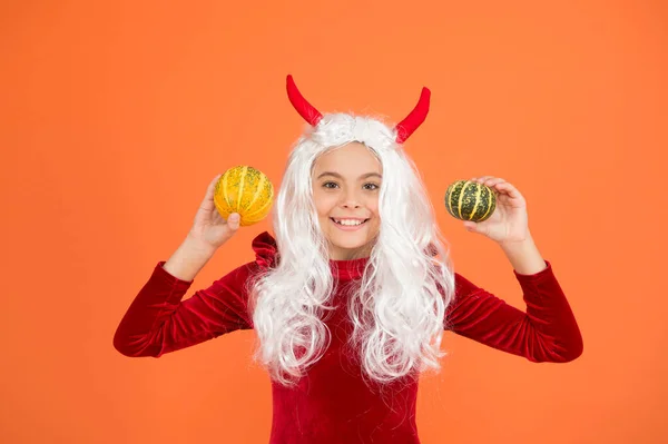 Happy halloween devil girl in imp horns hold pumpkin for jack o lantern, funny halloween — Stock Photo, Image