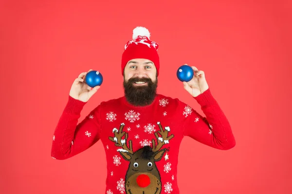 New year concept. Hipster smiling cheerful bearded man wear winter sweater and hat hold balls. Christmas party. Winter holidays. Winter decorations. How to handle top holiday stress triggers — Stock Photo, Image