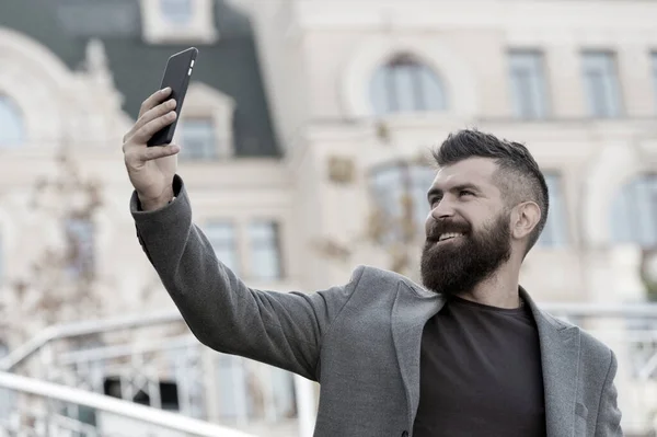 Ahoj. Muž s úsměvem fotit selfie smartphone městské pozadí. Probíhá vysílání online videohovoru. Mobilní internet. Mobilní telefon Hipster. Obsah blogu. Osobní blog. Moderní život. Mobilní internet — Stock fotografie