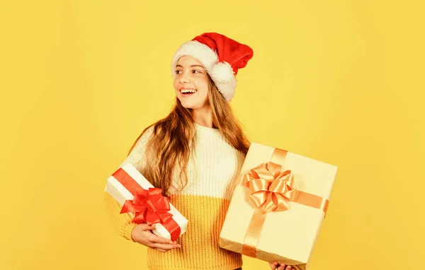 Julshopping på nätet. Dags för rabatt. leende unge hålla inköp. Presenter och presenter från tomten. liten flicka Santa på gul bakgrund. Julfestfirande. Gott nytt år — Stockfoto