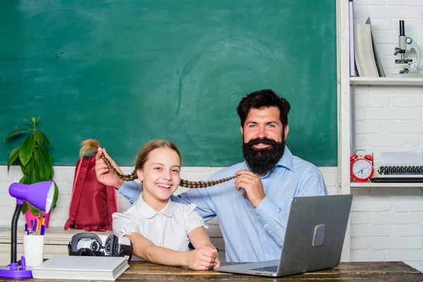 Study modern technologies. Man bearded pedagogue teaching informatics. Homeschooling with father. Find buddy to help you study. Private lesson. Study online. School teacher and schoolgirl with laptop