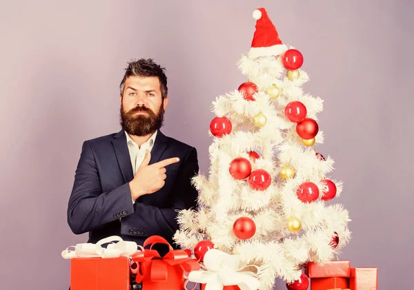 Preparazione e celebrazione. L'uomo barbuto hipster indossa un completo formale vicino all'albero di Natale. Lista di controllo preparazione di Natale. Regali e decorazioni natalizie. Come organizzare una fantastica festa di Natale in ufficio — Foto Stock