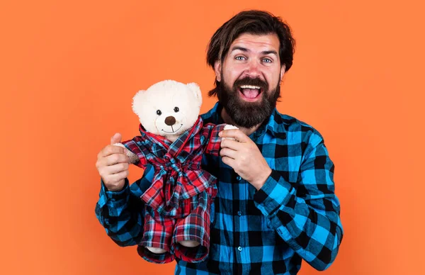 Homem barbudo hipster caucasiano com barba longa em camisa xadrez e ursinho de pelúcia marrom bonito para dia dos namorados, presentes e presentes — Fotografia de Stock