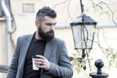 Kahve molası. Hippi elinde kağıt kahve fincanı tutar ve park ortamının tadını çıkarır. Giderken iç. Sakallı hippi adam kahveyi tercih ediyor. İş adamı sakallı adam dışarıda kahve içiyor.