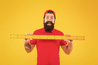 Mükemmel boyut. Büyük bir ölçü aleti olan sakallı bir adam. Cetvelle ölçüyorum. Boyut ölçüsü. Uzunluk ölçüsü. Giysiler. Öğrenci kök disiplini. Cetvel aletleri. Dükkan asistanı