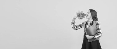 Mutlu öğrenci. Küçük mutlu okul çocuğu sarı yaprak kitapları tutuyor. Sonbahar yapraklarıyla gülümseyen küçük kız. Sonbahar tatilini kutlayın. Mutlu sonbahar sezonları. Okula geri dön, kopyalama alanı