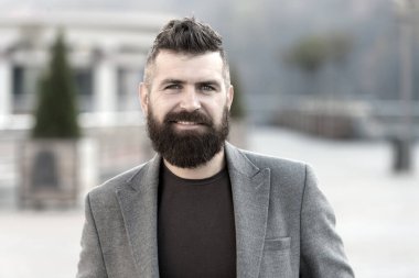 Sakallı adam. Sakallı moda adamı. Erkek berber bakımı. Sakallı, olgun bir hippi. Bıyıklı, vahşi, beyaz bir hippi. Gülümseyen adam dışarıda. Şık ve kendinden emin. sakal bakımı