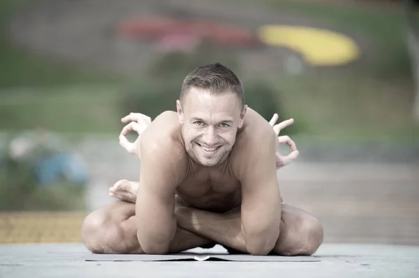 Hombre atlético haciendo asanas de yoga en el parque — Foto de Stock