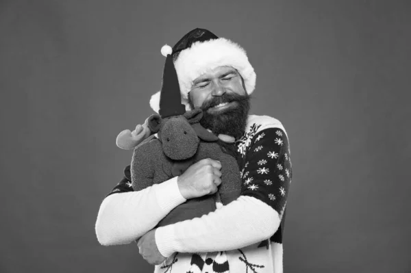 Z miłością. Brodaty facet przytula miękką zabawkę. Szczęśliwy hipster obejmuje prezent świąteczny. Noworoczny uścisk. Świąteczny uścisk. Szczęście to ciepły uścisk. — Zdjęcie stockowe