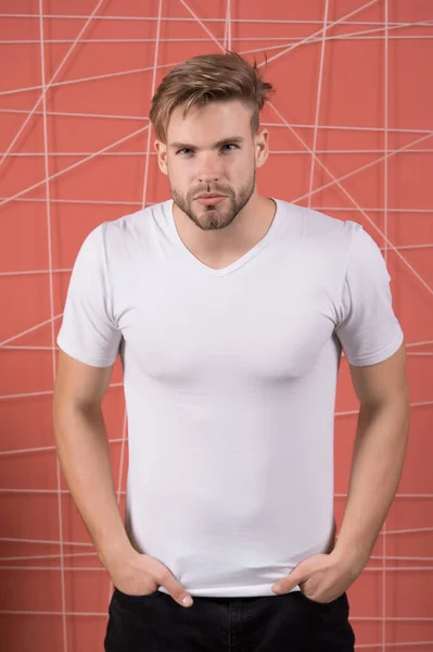 Man in the white tshirt with copy space standing on pink wall background — Stock Photo, Image