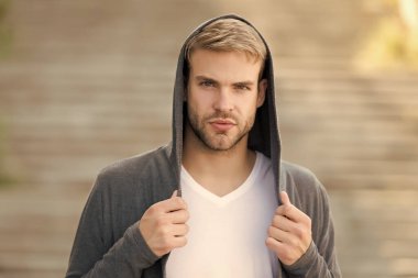 Mükemmel erkek. Moda mankeni genç adam. Kapüşonlu bir adam. Kapüşonlu genç sokak adamı. Kimlik değiştiren çocuk. Şehir içinde kapüşonlu yakışıklı bir adam var. gayri resmi kıyafet