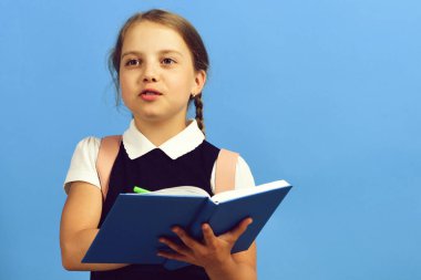 Okul üniformalı, örgülü bir öğrenci. Mutlu yüzlü kız.