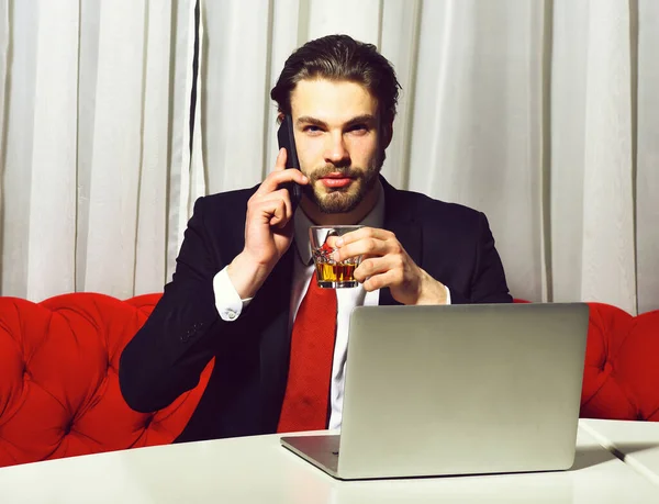 Szakállas férfi, üzletember kezében üveg whiskey működik a laptopon — Stock Fotó
