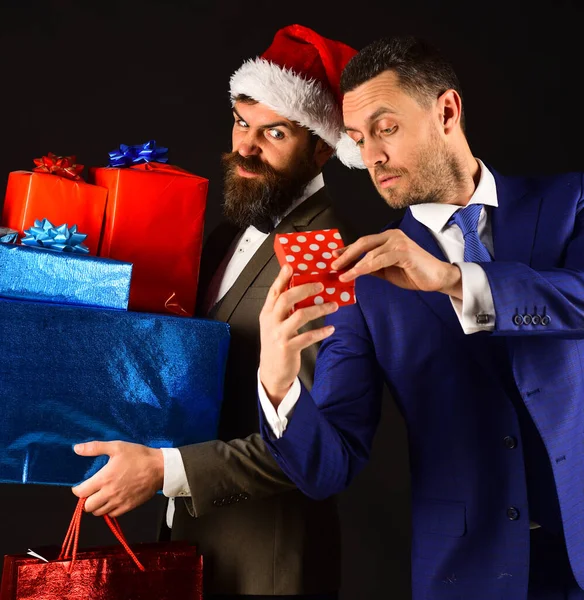 Mannen in slimme pakken en Santa hoed op zwarte achtergrond. — Stockfoto