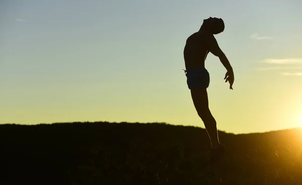 Силуэт спортсмена, прыгающего на фоне заката, пространство для копирования. — стоковое фото