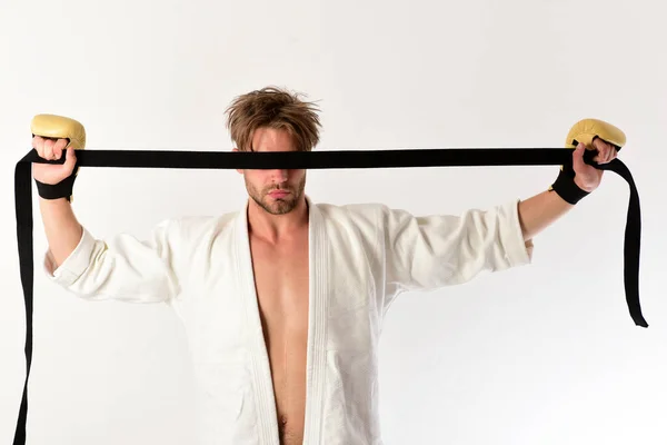 Man with hidden sight holds black belt on white background.