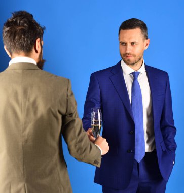 Başarılı iş adamları şampanya içiyor, konuşuyor ve gülümsüyor.