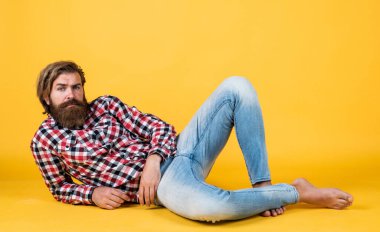 Moda görünüyor. Yakışıklı, kendine güvenen bir adamın mükemmel bir saç stili var. Kareli gömlekli mutlu sakallı adam. Erkek güzellik konsepti. Sakallı hippi portresi. Uzun, gür sakallı ve bıyıklı adam.