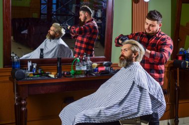 Hippi saç tıraşı oluyor. Saçları boyalı bir adam. Berber berber dükkanı. Berber kozmetik. Kuaför aletleri. Berber işlemler üzerinde yoğunlaşmıştı. Saç şekillendiriyorum. İşlemleri değiştirmek neredeyse imkansız.