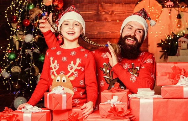 Come Santa Clause and dont delay. Father and child with gifts from Santa Claus. Father and daughter wearing Santa Claus hats. Happy family celebrate Christmas and new year. We believe in Santa Claus