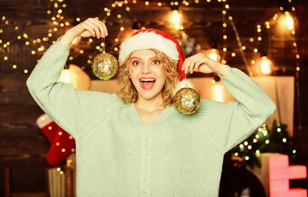 Últimos preparativos. férias de inverno decorações. Feliz Ano Novo. preparação de Natal. Uma rapariga de chapéu vermelho de Pai Natal. Bola de decoração de ano novo. Uma mulher alegre. decorar a árvore de Natal — Fotografia de Stock