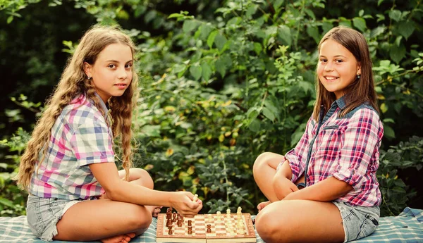 Когнитивное развитие. Интеллектуальная игра. Прими решение. Умные дети. Девочки играют в шахматы. Сестры играют в шахматы. Дети играют в шахматы на природе. Спорт и хобби — стоковое фото