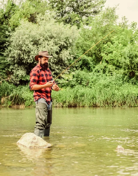 Un pescatore barbuto. Attrezzatura da pesca dei pescatori. Stagno lagunare del lago fluviale. Un allevamento di trote. Pescatore solo stare in acqua di fiume. Hobby attività sportive. Pesca piscicoltura allevamento del pesce commercialmente — Foto Stock