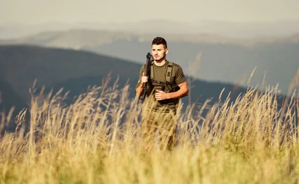 Hunter szabadidős vadászattal tölti az idejét. Séta a hegyekben. Vadászat férfi hobbi koncepció. Ember brutális vadőr természet táj háttér. A vadászat szabályai. Hunter fogja meg a puskát. Szép nap a vadászatra. — Stock Fotó