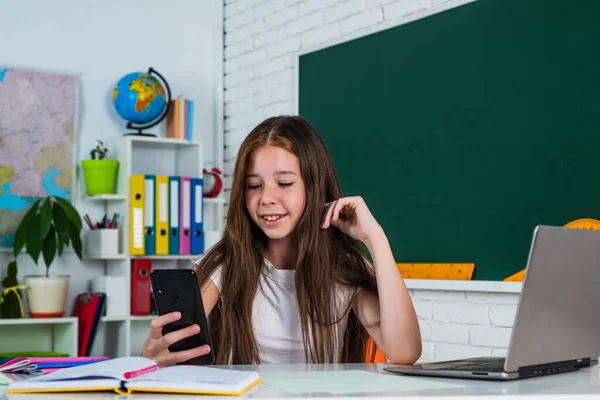 Meisje in de klas school met smartphone, online onderwijs — Stockfoto