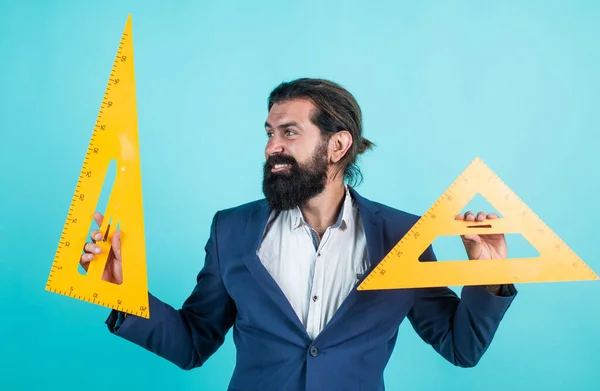 architecht or lecturer on math lesson. back to school. formal education. measure and size. happy mature teacher holding triangle tool. bearded man engineer work with ruler. prepare for geometry exam
