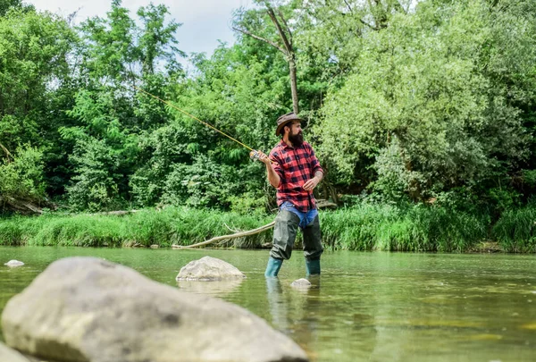 Ervaar de Legende. ervaren visser in het water. Mensen die vis vangen. volwassen man vliegen vissen. visser tonen visserij techniek gebruik staaf. Succesvolle vliegvissen. Zomers weekend. sport activiteit hobby — Stockfoto