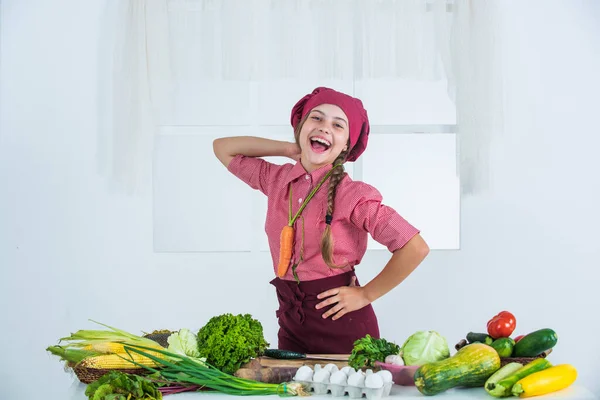 Glad flicka med färgglada grönsaker i köket, ekologisk mat — Stockfoto