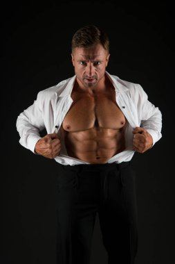 Güçlü bir adam açık tişörtlü, formda, karın kaslı, resmi siyah arka plan, karın kaslı.