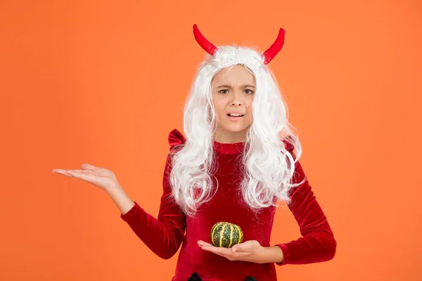 Halloween Teufelskind in Wichtelhörnern hält Kürbis für Jack o Laterne, präsentiert Produkt auf Kopierfläche, fröhliches Halloween — Stockfoto