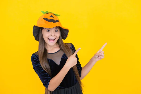 Niño en sombrero de calabaza apuntando con el dedo en el espacio de copia. Un chico usando calabaza. fiesta de disfraces de carnaval. truco o trato. celebrar la fiesta. Jack o Linterna. feliz chica de halloween en sombrero de calabaza —  Fotos de Stock