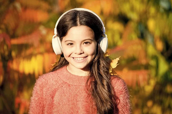 Genießen Sie den Herbsttag. Guter Tag für einen Parkspaziergang. Sie liebt die Natur und die Musik. Schulzeit. Herbststimmung. Kleines Mädchen hört Hörbuch. Kleines Kind im Headset. Online-Bildung. eBook für Kinder — Stockfoto