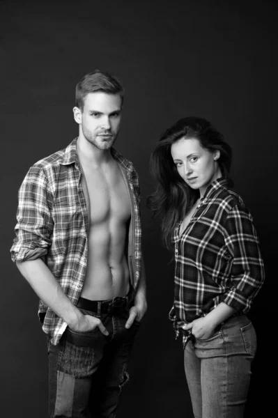 Family look. Fashion trend. Fashionable outfit. Woman and man wear checkered shirt. Sexy stylish couple black background. Young family couple. Summer fashion collection. Beautiful people concept