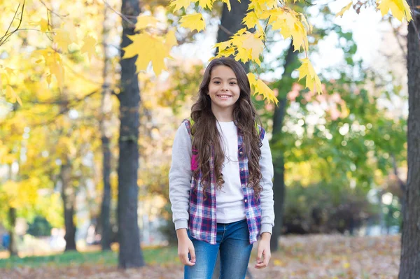 Glad flicka i avslappnad stil tillbringa tid promenader i höstparken njuta av bra väder bära ryggsäck, tillbaka till skolan — Stockfoto