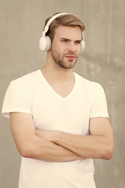 Tecnologia moderna. Música moderna e contemporânea. Lazer de passatempo. Auriculares estéreo dobráveis. Redução de ruído. Fone de ouvido sem fio. Um tipo bonito usa auscultadores fundo cinzento. Homem ouvir música moderna — Fotografia de Stock