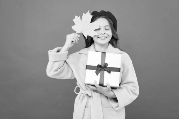 Ημέρα των Ευχαριστιών. Φθινοπωρινή. Σχολικές πωλήσεις. Κορίτσι παιδί στα γαλλικά μπερέ κρατήσει δώρο. Φθινοπωρινή αλλαγή. Ευτυχισμένο κοριτσάκι με φύλλα σφενδάμου και κουτί δώρου. Φθινοπωρινή παιδική μόδα. Στιγμές χαράς — Φωτογραφία Αρχείου