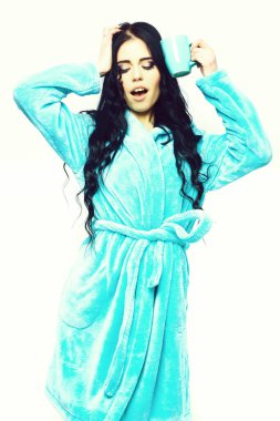 Turkuaz kadife bornozla fincanla poz veren seksi kız.