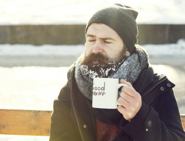 Kaşlarını çatan adam bardaktan içer.