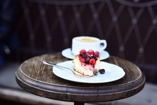 Cheesecake with berries and coffee on wooden table — Stock Photo, Image