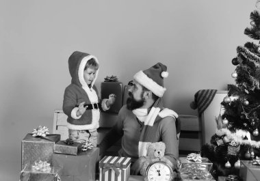 Noel Baba ve küçük asistan hediye kutularının arasında. Sakallı adam